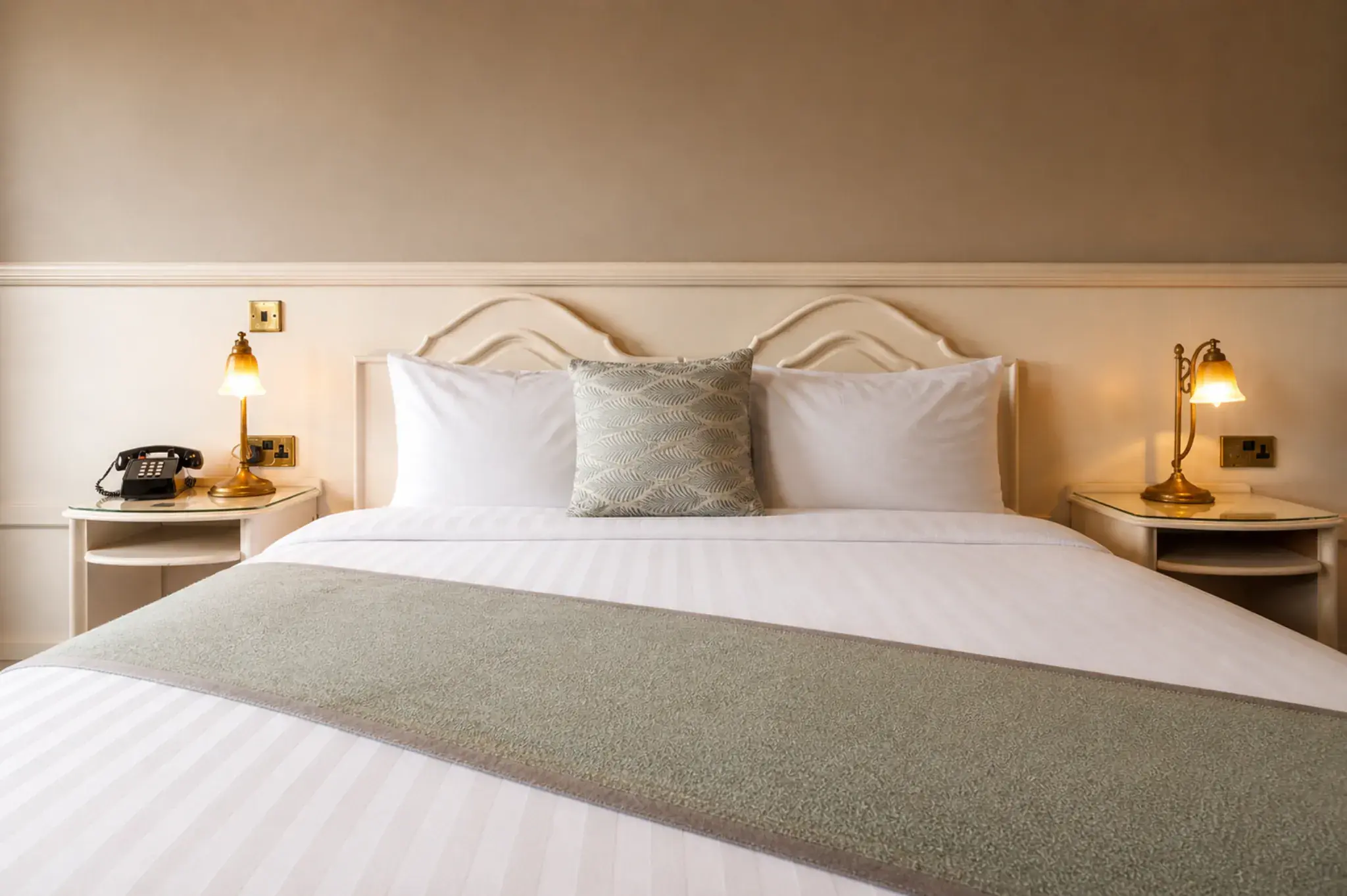 Double bedroom at The Lakeside Manor with plush bedding and a classic wooden headboard